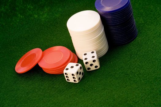 stacks of chips an dice on green felt background