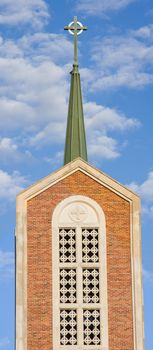 panorama of church steeple on puffy cloud filled sky 