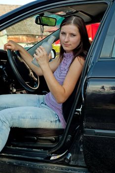 Woman drinking alcohol during a drive in a car