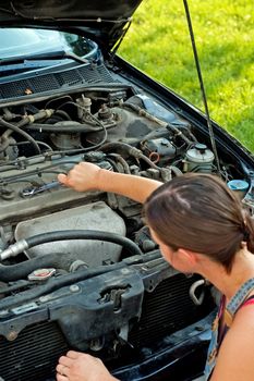 Young woman repairing her car