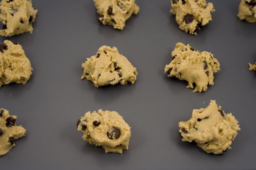 A cookie sheet of chocolate chip cookies ready for the over.