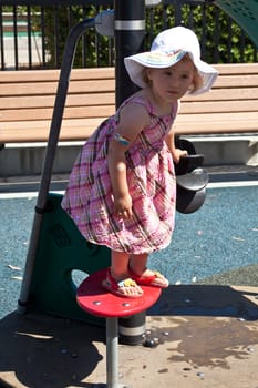 Cute little European toddler girl having fun at the playground in park
