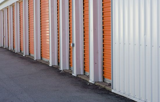 Row of orange door from a storage warehouse alarm system seen at the bottom of each door