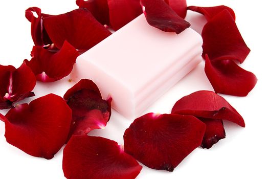 Pink soap with rose petals on white