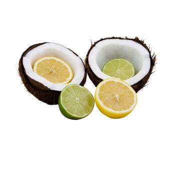 Lemon and lime cut in half placed in front of and inside a coconut that is split open  isolated on a white background