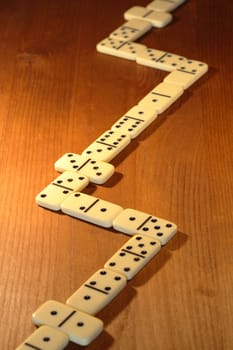 Long line made from dominoes on wooden background