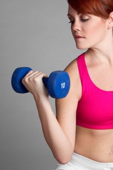 Pretty fitness woman lifting dumbbells