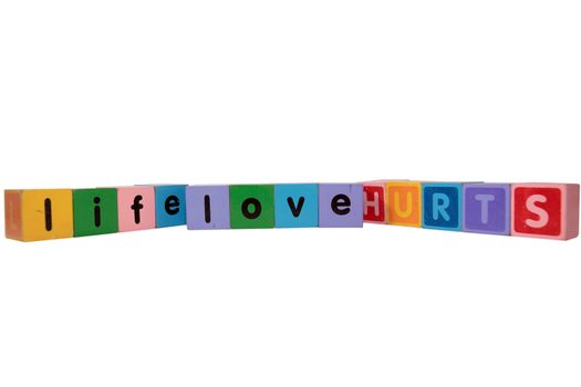 toy letters that spell life love hurts against a white background with clipping path