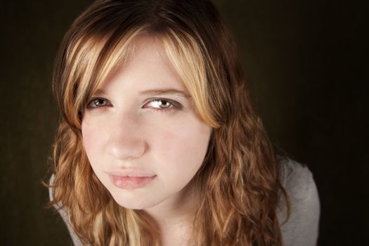 Close up of skeptical teenage girl on green background