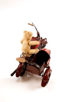 Teddy riding a motorbike toy
