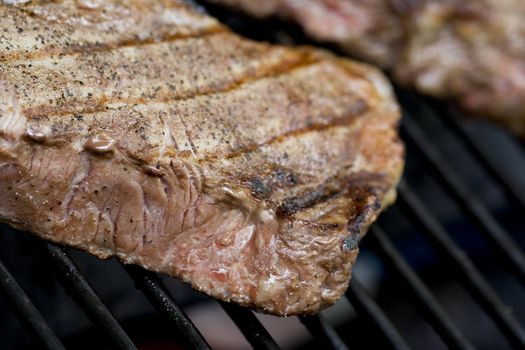 Grilling steaks on the grill nice cuts of meat close up shot shallow DOF