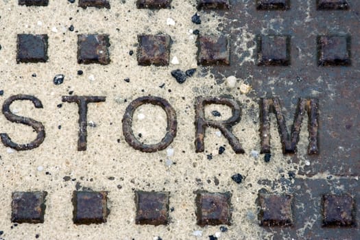 Storm Drain manhole cover rusty and washed with sand