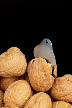 A stack of walnuts wiht a heart shaped nutcracker