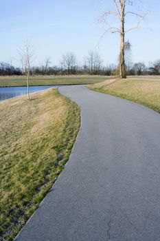 paved hiking trail in the spring along small lake