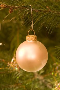 christmas bulb hanging on tree lights reflecting on it