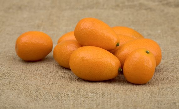 Fresh orange kumquat on the sacking background