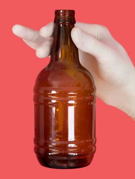 Brown bottle in hand on the red background