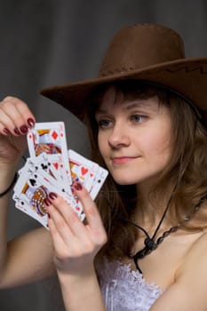 Portrait girl with a playing-cards in hand on black