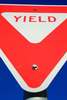 Yield road sign over clear blue sky.
