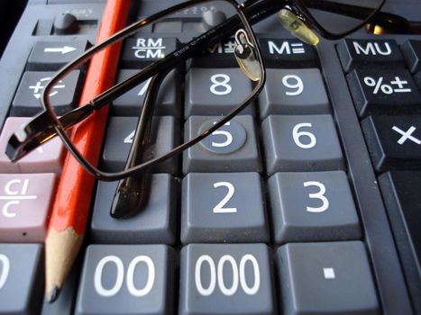 calculator, pen, glasses and some calculations