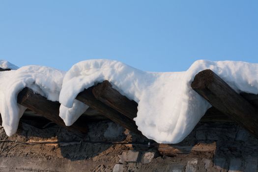 Wooden roof, drooping snow, winter, sunny, blue sky