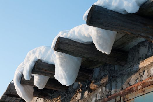 Wooden roof, drooping snow, winter, sunny, blue sky