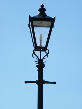 Isolated antique street lamp against a blue sky background