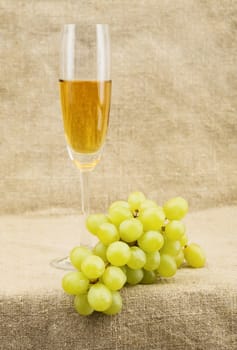 Still-life with a glass of wine and grapes on sacking background