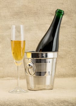 Still-life with a glass of wine and a bottle on sacking background