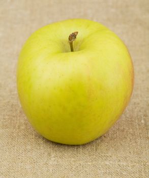Yellow ripe apple on sacking background