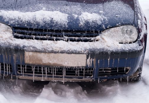 Frozen car covered with snow and ice