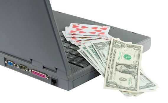 Laptop, playing cards and dollars on the white