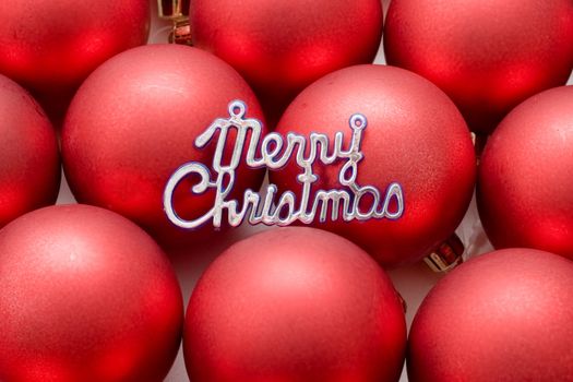 Holiday still life with bright red decorations and the words Merry Christmas