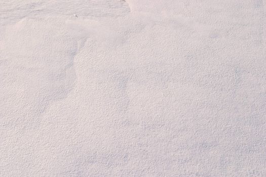 Texture of the snow. Thin snow crust on the surface of the frozen lake. Natural sunlight emphasizes texture. Pattern # 3