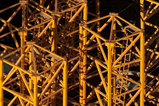 Industrial background. Part of high-rise construction crane lit bright sun