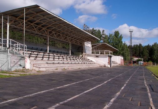 The small stadium with stands and benches for spectators, running tracks are visible with rubber coating