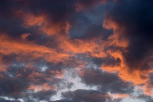 Dramatic storm clouds lit by the setting sun