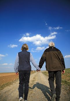 An elderly married couple going for a walk