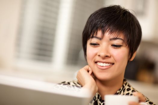 Pretty Smiling Multiethnic Woman Using Her Laptop Computer.