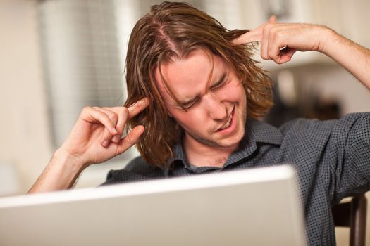 Young Man Getting Loopy While Using His Laptop Computer.