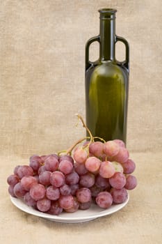 Bottle of wine and grape on the sacking