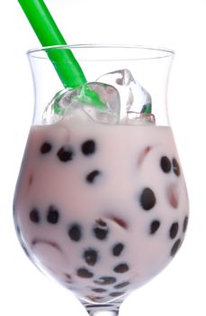Pink cocktail with tapioca balls, ice cubes and gren straw