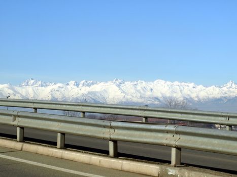 Mountains panorama background with motorway in front showing contrast between natural and built environment