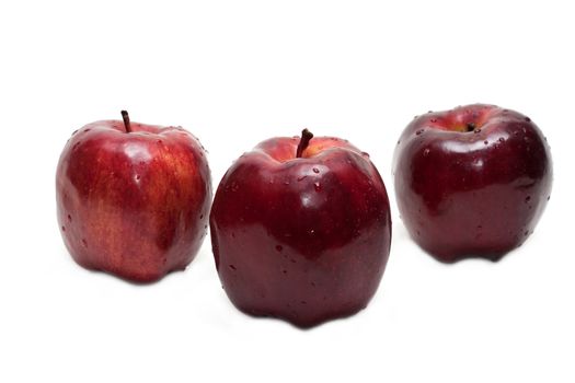 Three red apples, in droplet grow insulated on white background