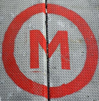 Diamond steel plate industrial iron metal background with M symbol (meaning metro underground tube subway)