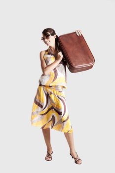 Beautiful young fashion woman posing with a old suitcase
