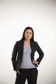 Portrait of Caucasian mid adult professional business woman standing with hand on hip looking at viewer.