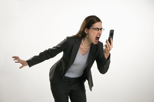 Caucasian mid adult professional business woman yelling into cell phone in anger.