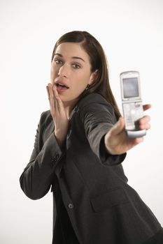 Caucasian mid adult professional business woman taking picture of self with camera phone with hand on chin.