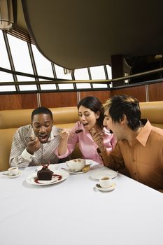 Small group of mid adult friends eating dessert at a restaurant.